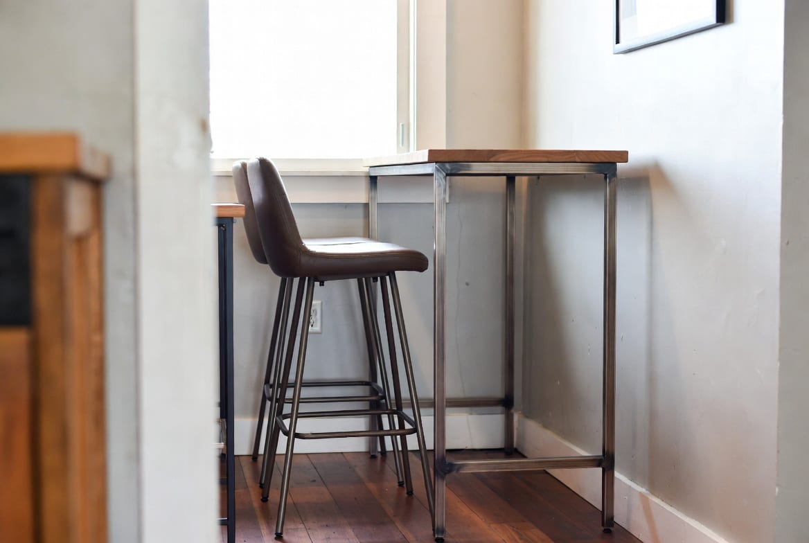 Modern bar leaner table with stools in small cafe or home space New Zealand