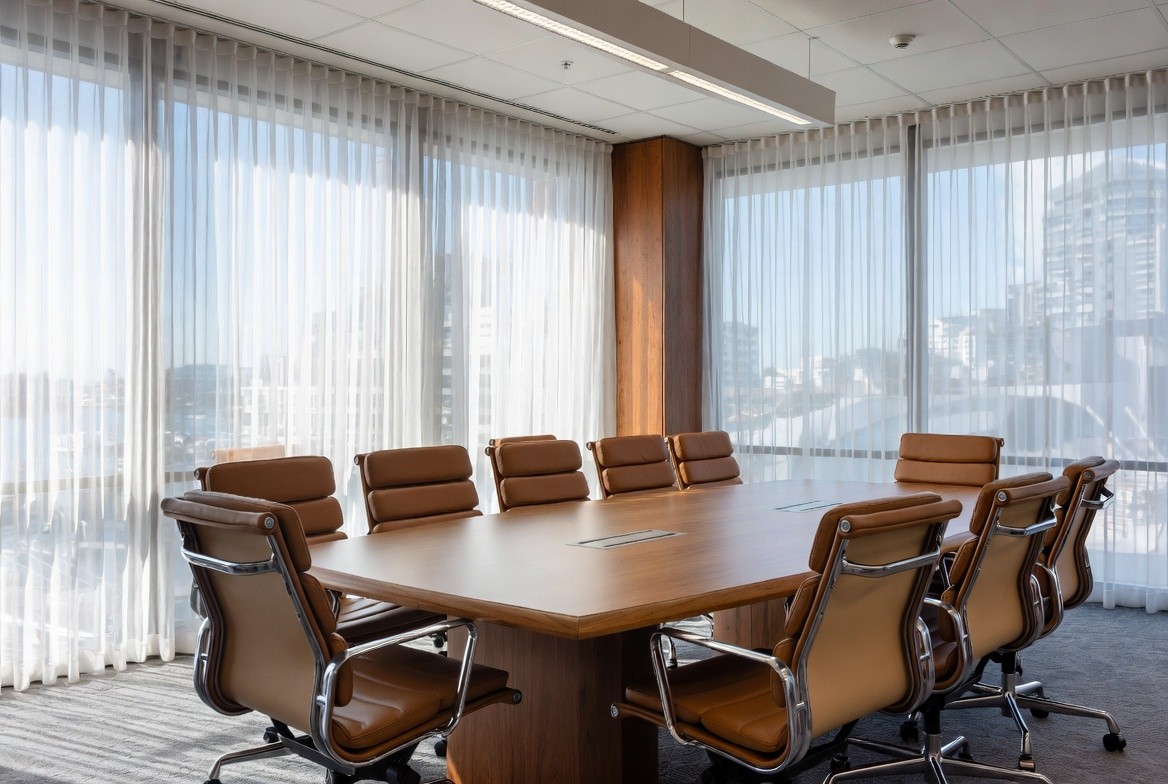 Professional modern boardroom with large conference table and ergonomic meeting chairs in bright New Zealand office