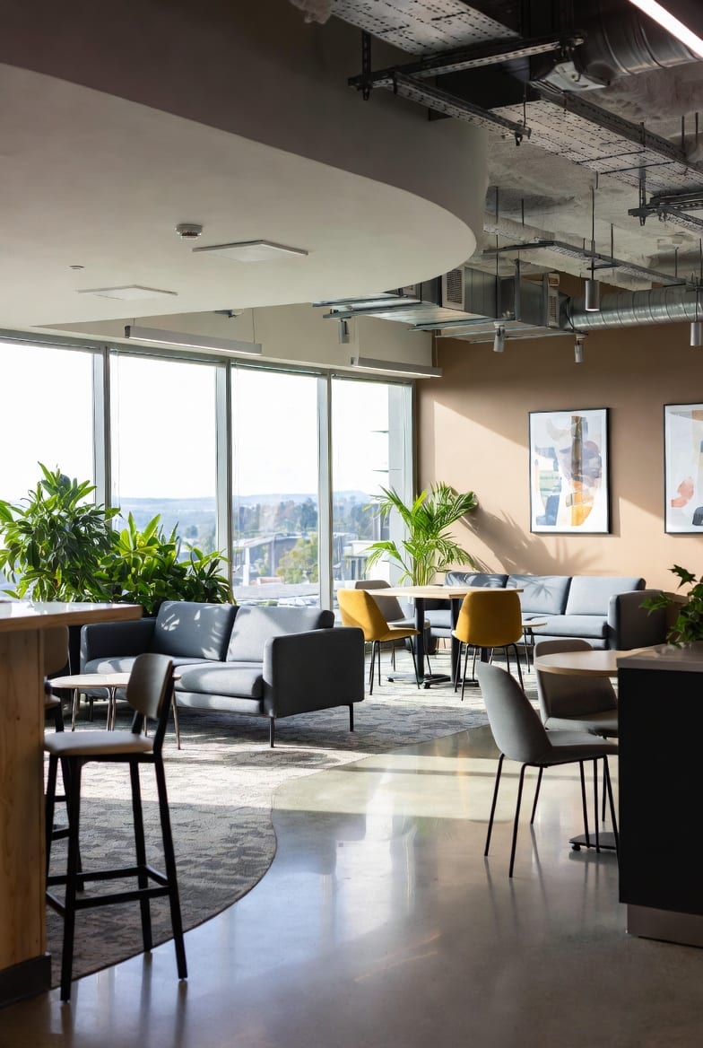 Modern office breakout space with comfortable seating and bar leaners in bright NZ office