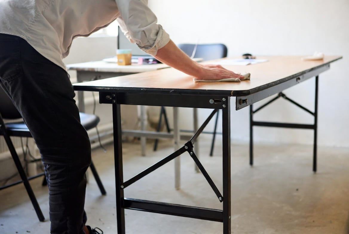 Person cleaning and maintaining a folding table properly