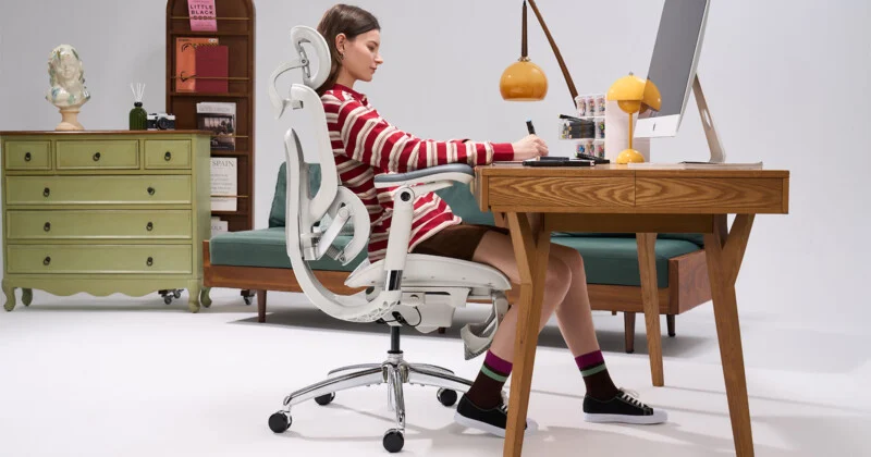 Person sitting comfortably in a high back ergonomic office chair at a modern NZ workspace