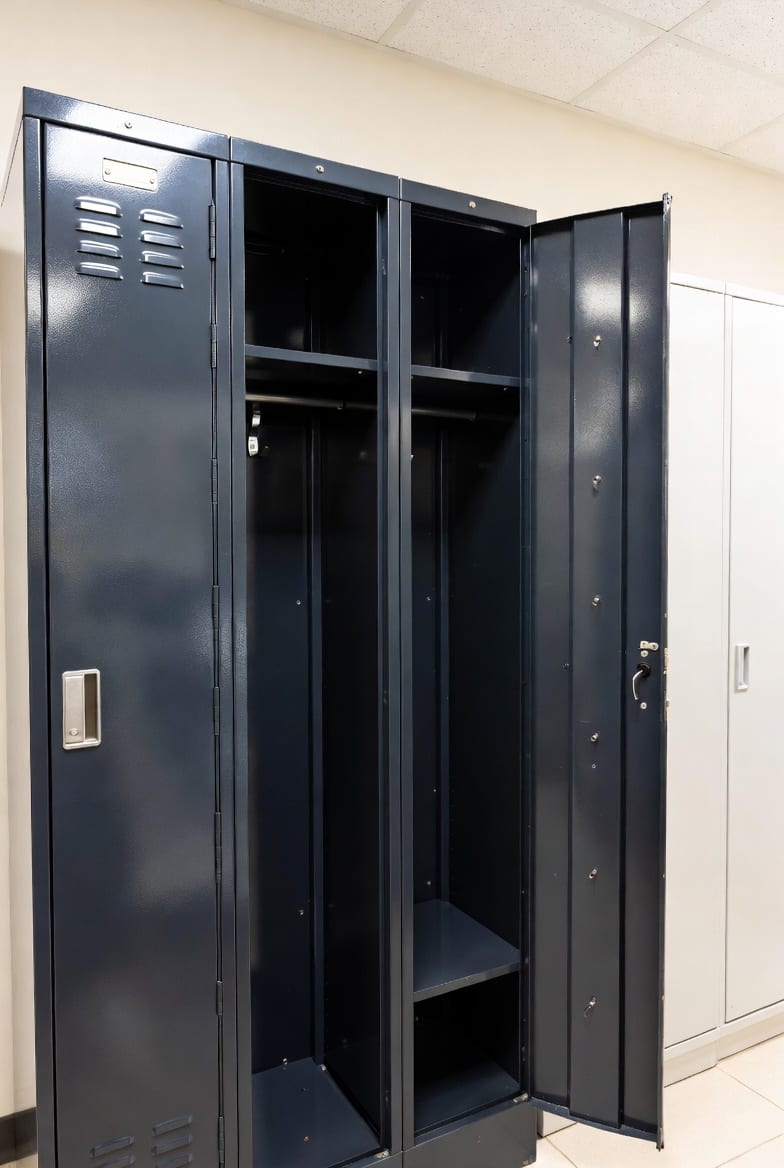 Black metal locker cabinet with open door showing internal hooks and shelves in office setting