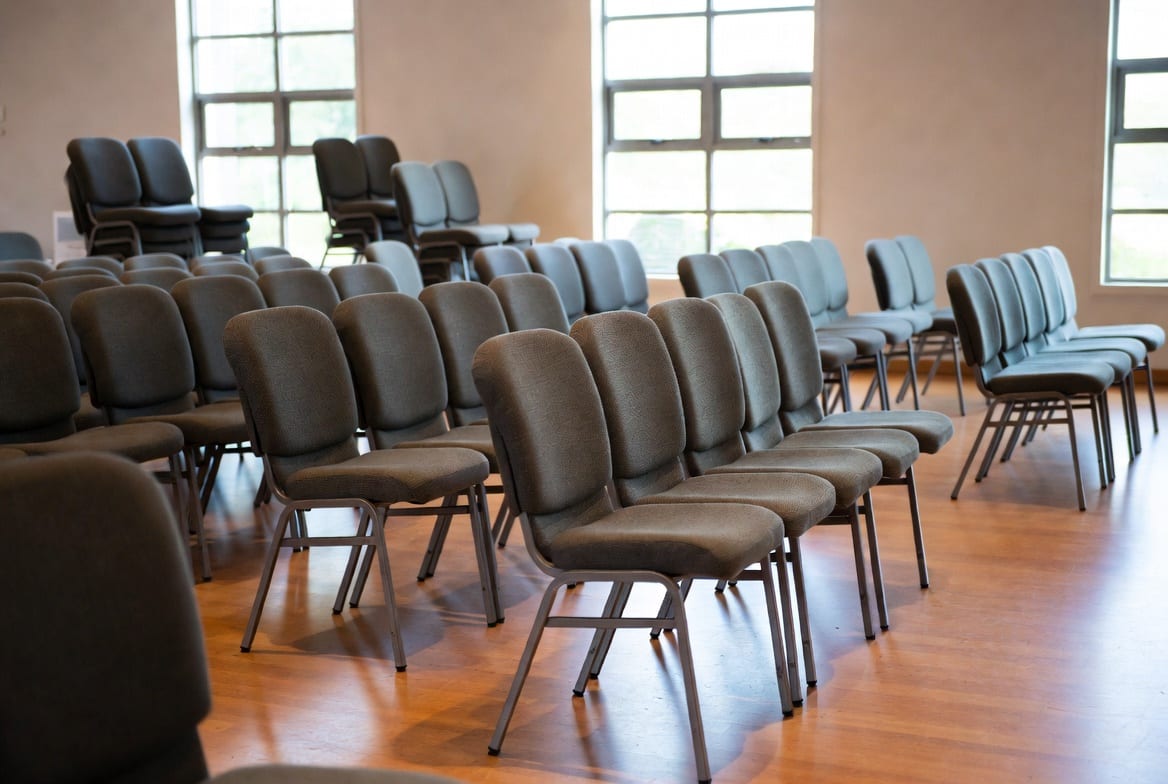 Stackable upholstered church chairs linked in rows inside a New Zealand church