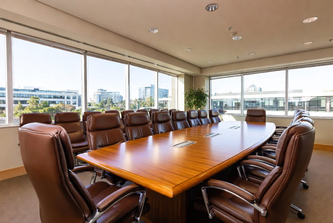 Large modern boardroom table set up for a meeting in a bright New Zealand office