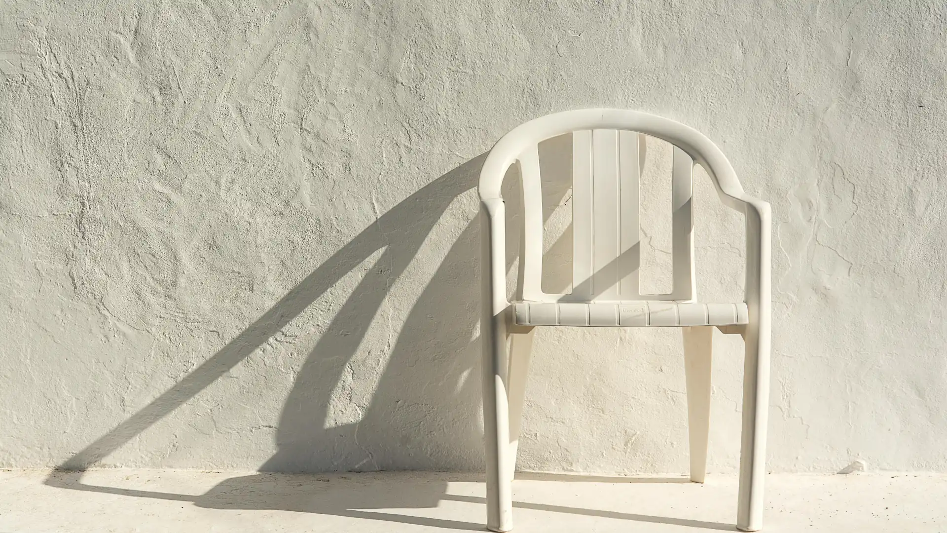 White plastic chair casting shadow