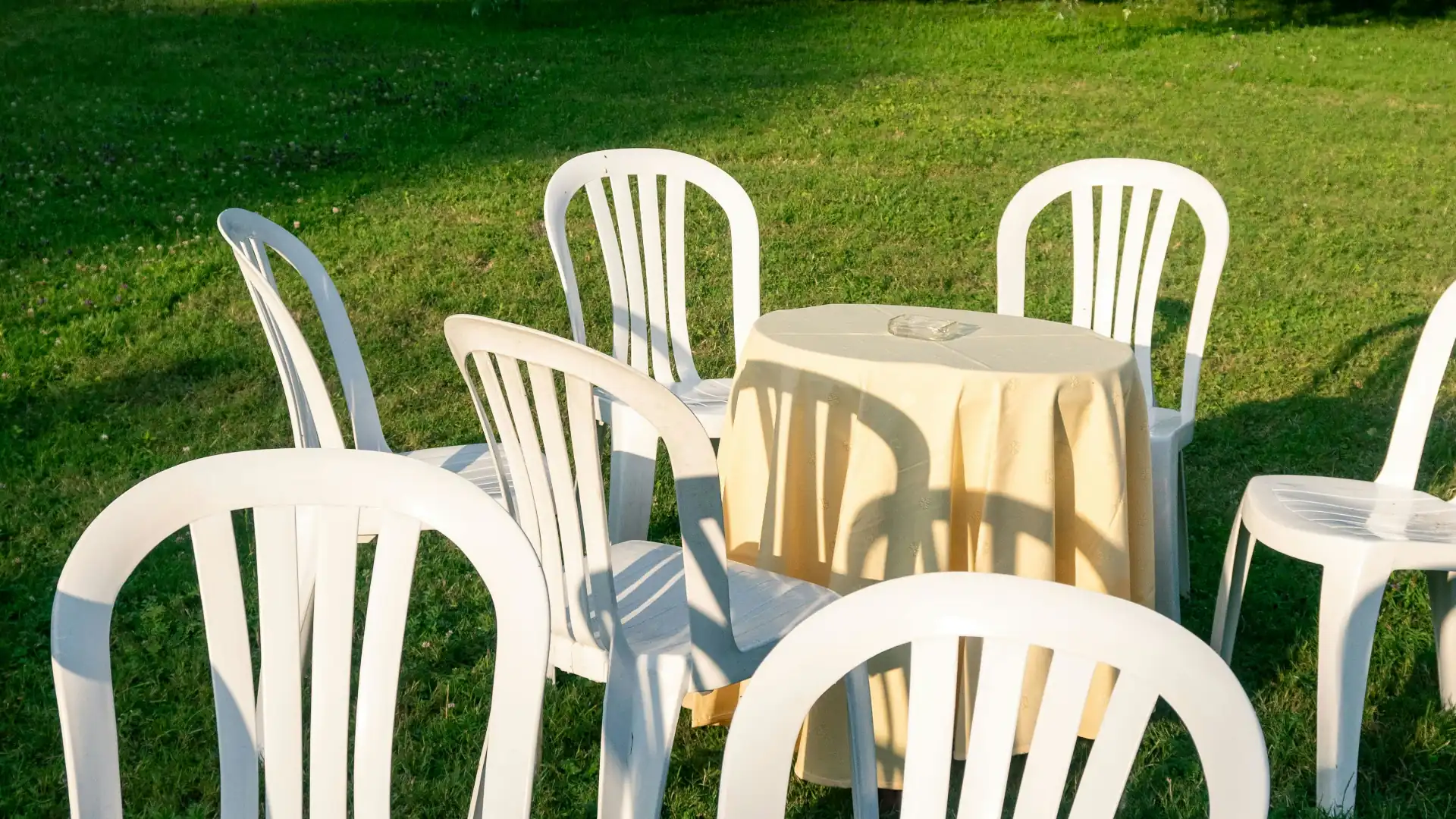 Outdoor event set up with plastic chairs arranged in a garden