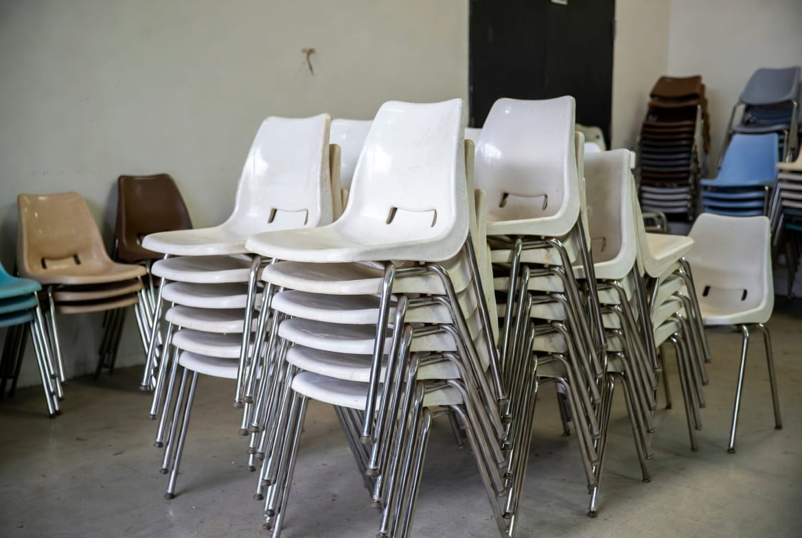 Stackable plastic chairs neatly stacked for storage in a commercial venue