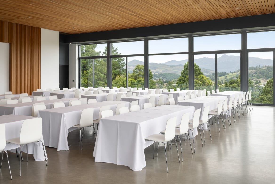 Rectangular folding tables arranged in rows for a conference or banquet in a New Zealand venue