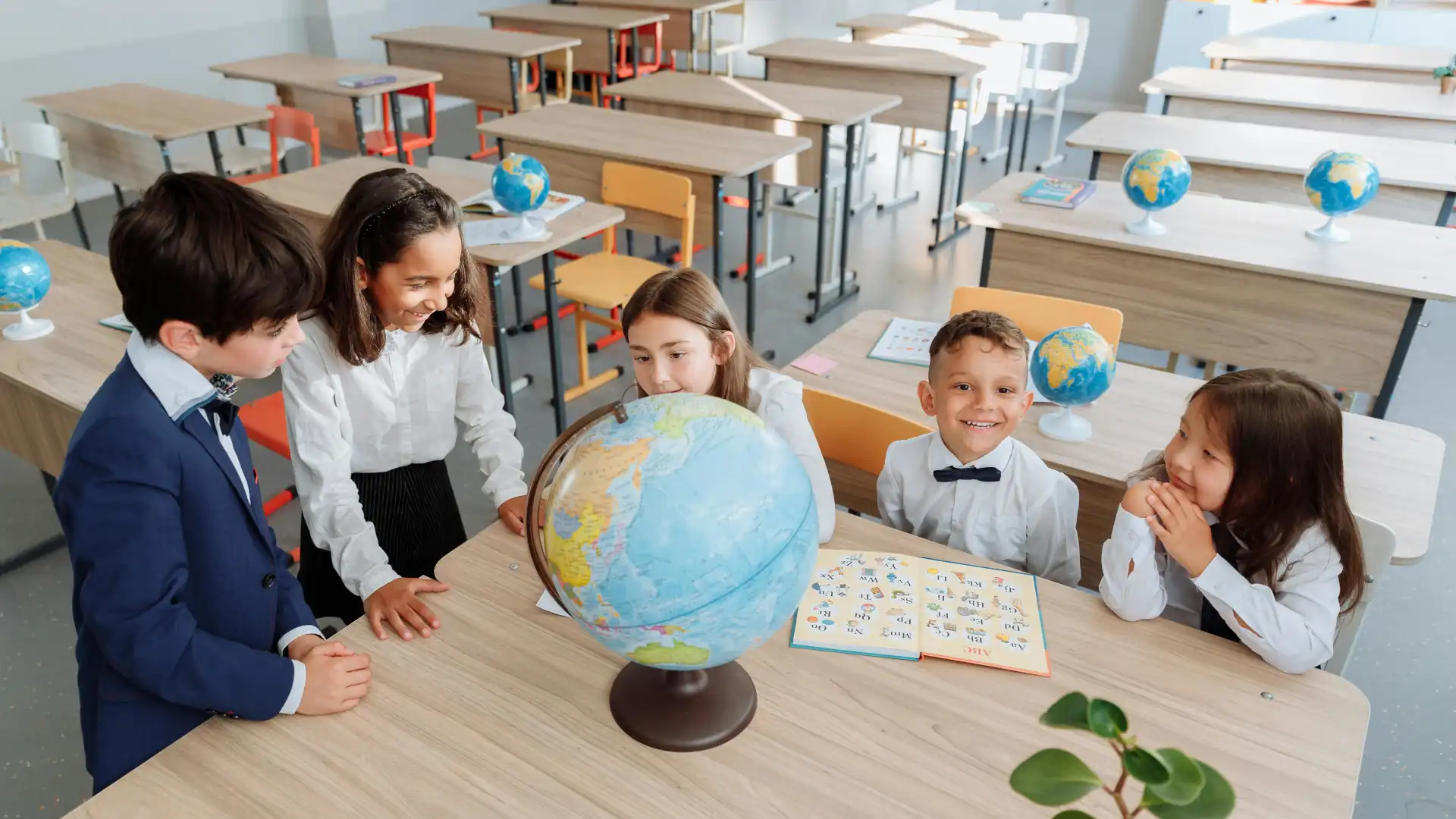 Group of students discussing the globe on a trestle table – educational setting